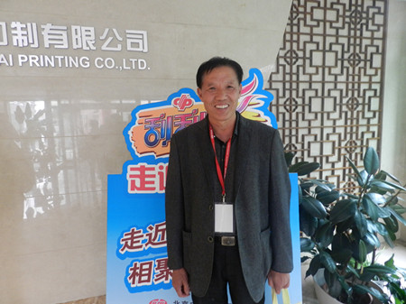 图为黄先生在北京中彩印制有限公司拍照留念