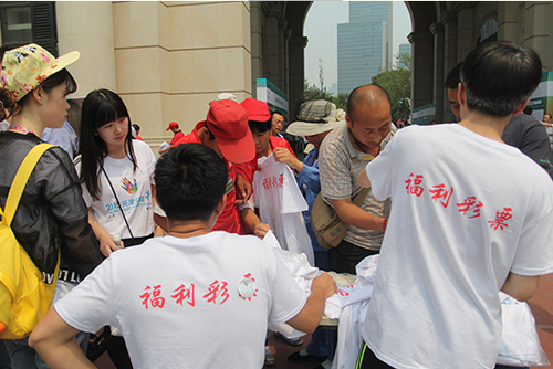 图三  市民踊跃领取“2015天津公益行”活动纪念T恤